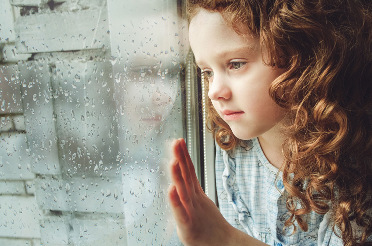 Sad child looking out window - What do you tell a child who is dying of a terminal disease?