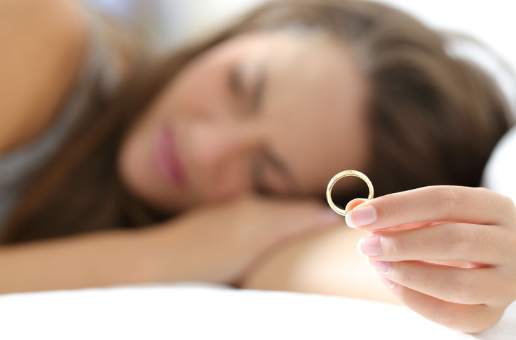 Divorced woman holding wedding ring - Are you living in adultery if you've been divorced and remarried?