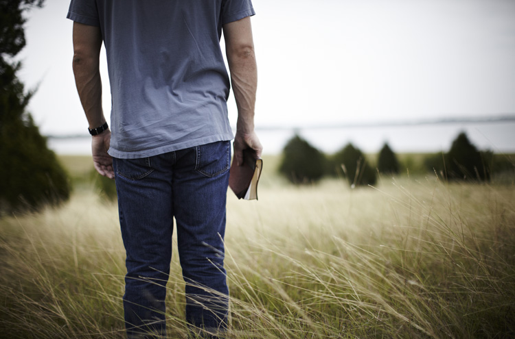 Man holding Bible, looking into distance - What part do good works play in your salvation?