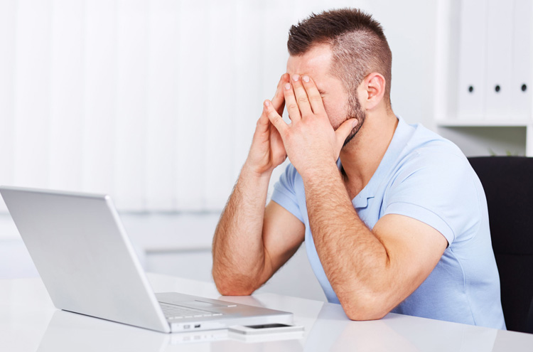Man sitting at laptop, frustrated - How do you get victory over sin?