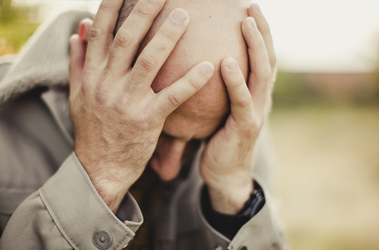 Man holding his head - Why do bad things happen to good people?