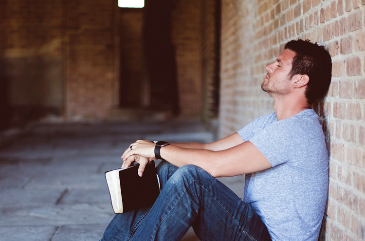 Man resting against wall with Bible - should you keep the sabbath