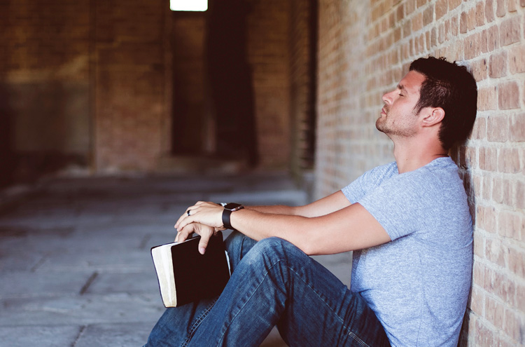 Man resting against wall with Bible - should you keep the sabbath