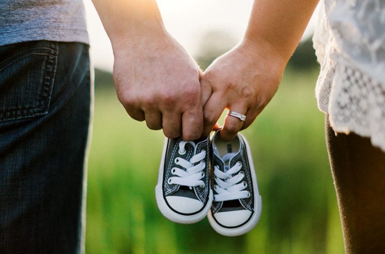 Parents holding baby shoes - Is it wrong to use birth control?