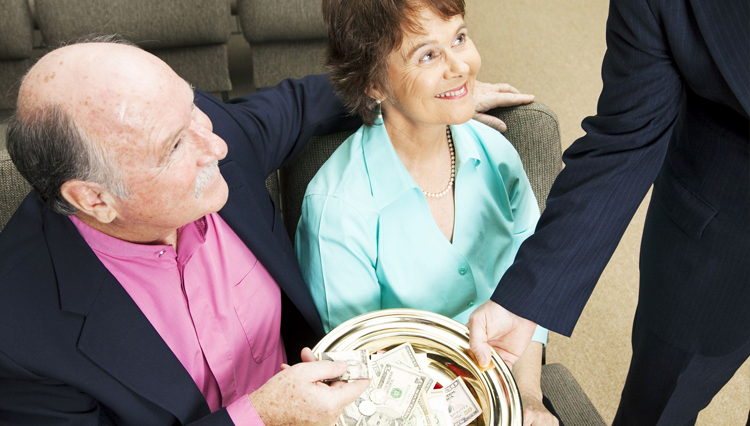 Couple placing money into offering plate - Is tithing to the local church a form of giving or paying