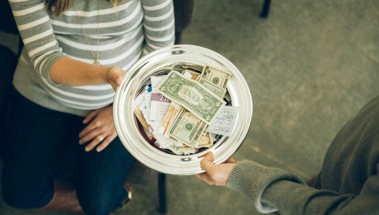 Man passing offering plate - Does the tithe belong to the local church?