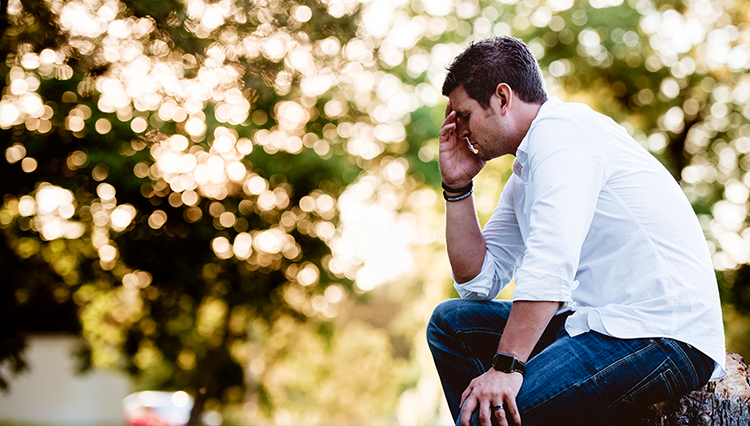 Man sitting on log, mourning - Are you characterized as being mournful?