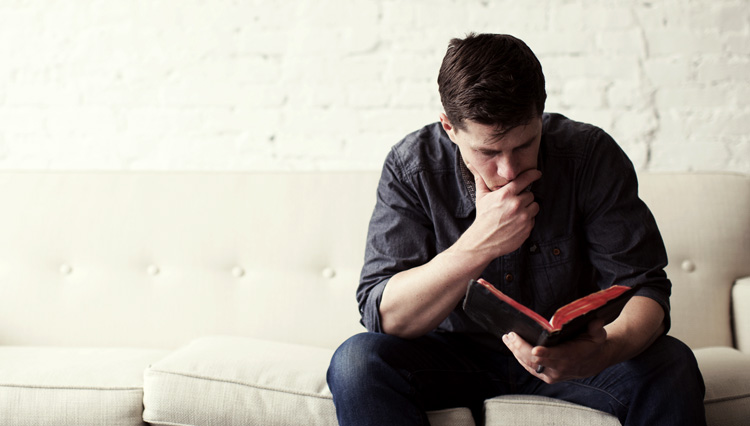 Man reflecting, reading Bible - how can you be sure that you've been born again?
