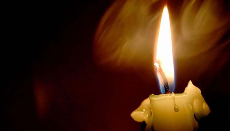 Picture of candle shining in the darkness