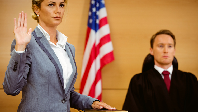 Woman swearing in court, with hand on Bible