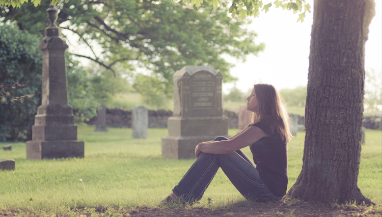 Woman sitting in graveyard, thinking about forgiveness, Heaven, and Hell