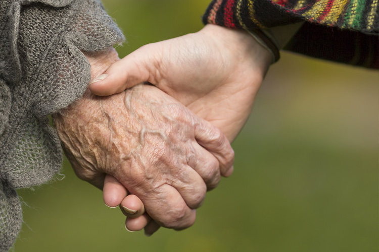 Picture of child holding elderly parent's hand