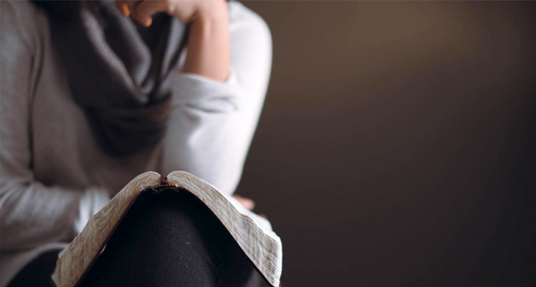 Picture of woman holding Bible and pondering