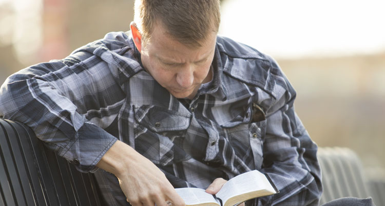 Man wondering if it's God's will for him to be healed, reading Bible